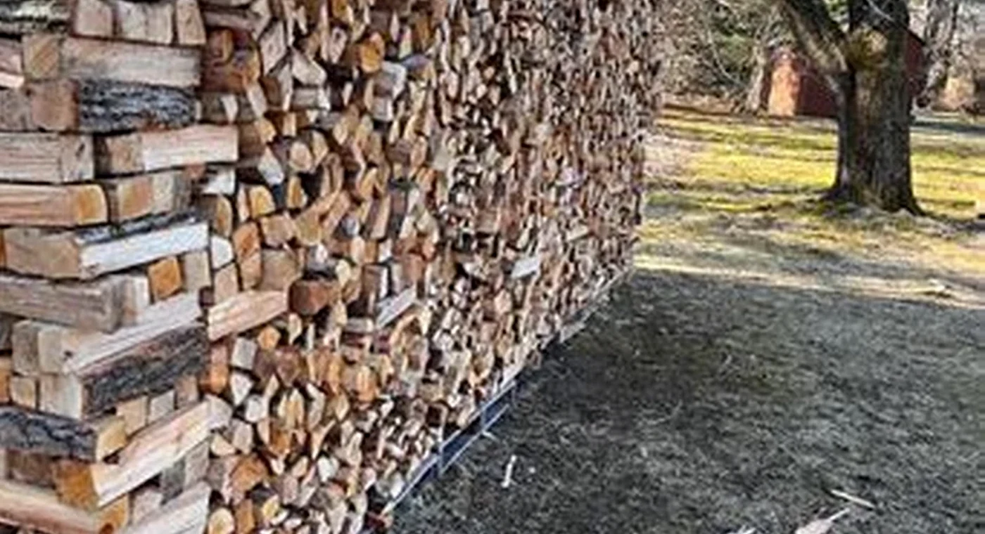 Real split firewood stacked outdoors; moisture and batch claims are confirmed separately.